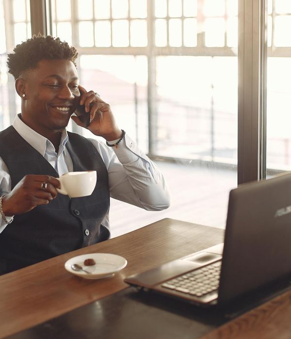 Smiling office worker taking a mindful break at their desk with natural light.